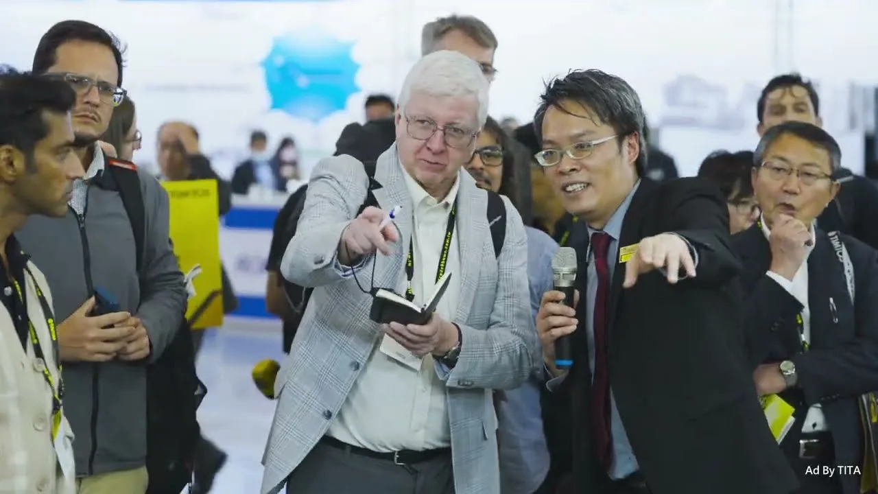 TIMTOS 2027 teaser frame: visitors examining a device at a stand in the Taipei Nangang exhibition hall