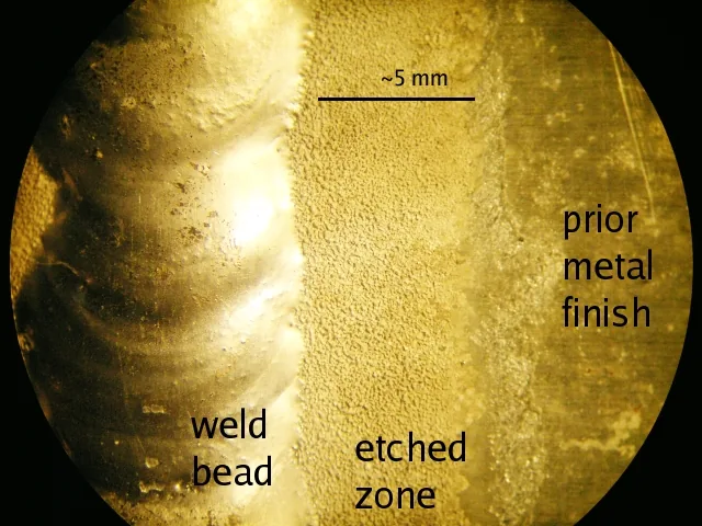 TIG weld bead on 4 mm 6061 aluminium plate, with a visible etched band about 5 mm wide beside it